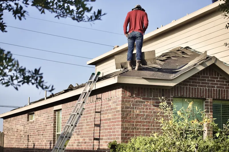 Professional roofer working on a residential roof in Center Groton